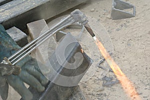 Workers at construction site cutting metal using blowtorch