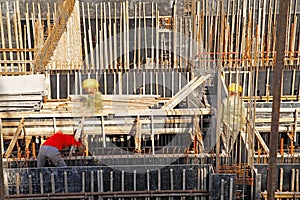 Workers in the construction site making reinforcement metal framework for concrete pouring