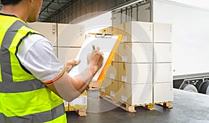 Workers Courier Holding Clipboard his Control Loading Package Boxes into Cargo Container.Supply Chain Commerce.Trucks Loading Dock