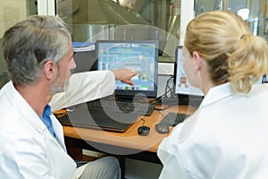 Workers discussing data on computer screen