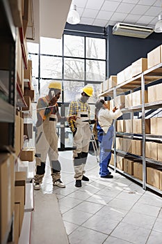 Workers discussing delivery schedule with distribution manager on phone