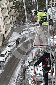 Workers dismantling temporary scaffolding wintertime