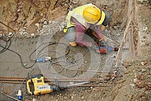 Workers drilling concrete using mobile drilling machine