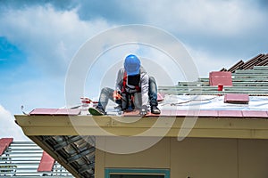 Workers are drilling roof tiles with a drill.