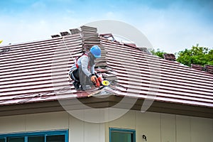 Workers are drilling roof tiles with a drill.