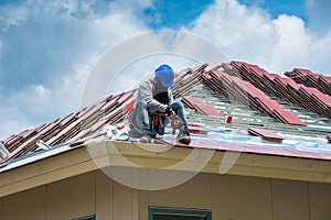 Workers are drilling roof tiles with a drill.