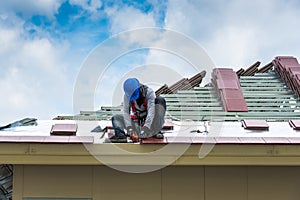 Workers are drilling roof tiles with a drill.