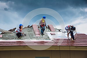 Workers are drilling roof tiles with a drill.