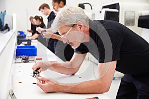 Workers In Engineering Factory Checking Component Quality photo