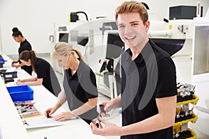 Workers In Engineering Factory Checking Component Quality