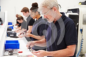 Workers In Engineering Factory Checking Component Quality