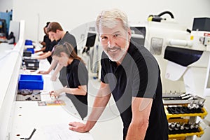 Workers In Engineering Factory Checking Component Quality