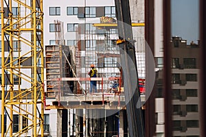 Workers engineers working at construction site and cranes on background of new building skyscrapers. Industrial landscape with bu