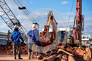 Workers with excavator drilling truck in construction site