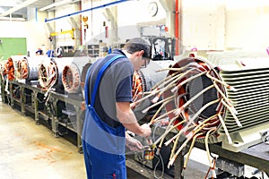 Workers in a factory assemble electric motors