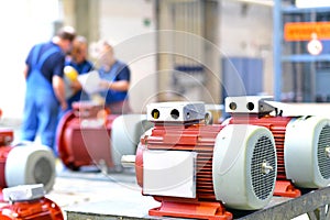 Workers in a factory assemble electric motors photo