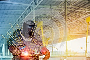 Workers in the factory at the welding plant steel structure.