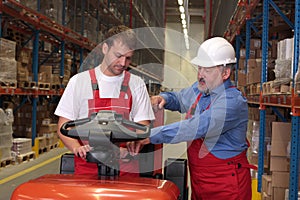 Workers with forklift in warehouse photo