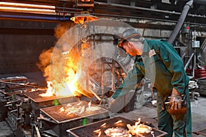 workers in a foundry casting a metal workpiece - safety at work and teamwork
