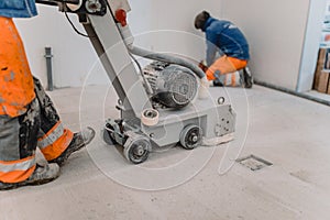 Workers grind the concrete floor at the construction site