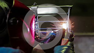 Workers grinding and welding metal chair in factory