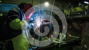 Workers grinding and welding metal chair in factory