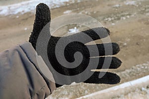 Workers hand in a black warm winter woolen glove