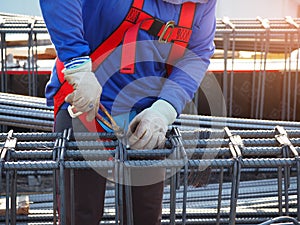 workers hands using steel wire and pincers to secure rebar photo