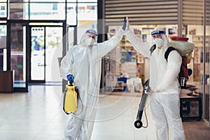 Workers in hazmat suits disinfecting indoor of mall, pandemic health risk, coronavirus
