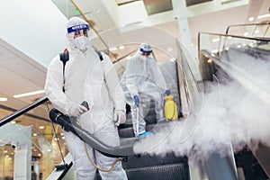 Workers in hazmat suits disinfecting indoor of mall, pandemic health risk, coronavirus