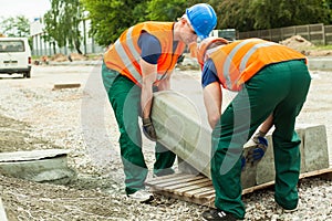 Workers heaving block of setts