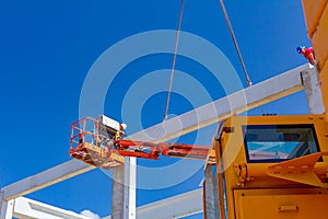 Workers are helping crane to keep balance and direction of concrete joist