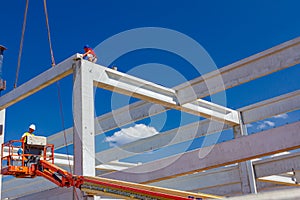 Workers are helping crane to keep balance and direction of concrete joist