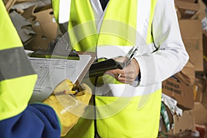 Workers Holding Clipboards In Industry