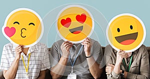 Workers holding happy face emojis