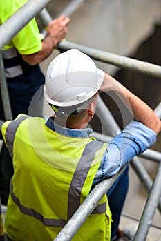 Workers inspecting construction works on a scaffold