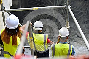 Workers inspecting construction works on a scaffold