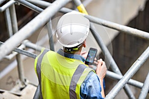 Workers inspecting construction works on a scaffold