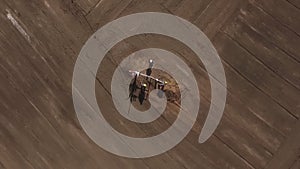 Workers are inspecting and servicing small oil well in field, , in summer day, aerial view