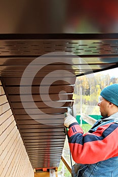 Workers install eaves under the roof of the house