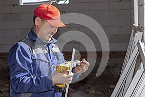 Workers install glazing in a house under construction