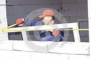 Workers install glazing in a house under construction