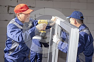 Workers install glazing in a house under construction