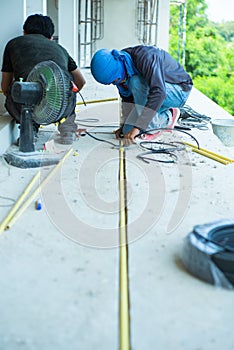 Workers installing the electrical wire and pipe in the house under construction