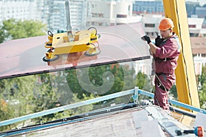 Workers installing glass window on building