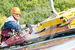 Workers installing glass window on building