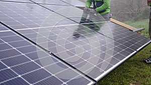 workers installing modern photovoltaic panels on garden huts