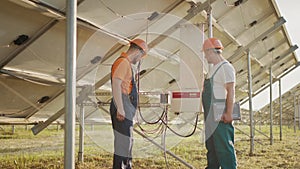 Workers installing PV Photovoltaic, solar panels, which converts solar energy into electric energy. Connecting and