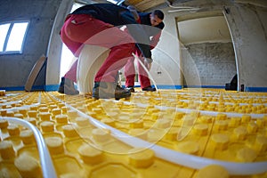 Workers installing underfloor heating system