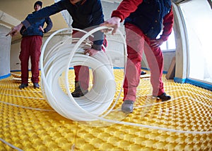 Workers installing underfloor heating system